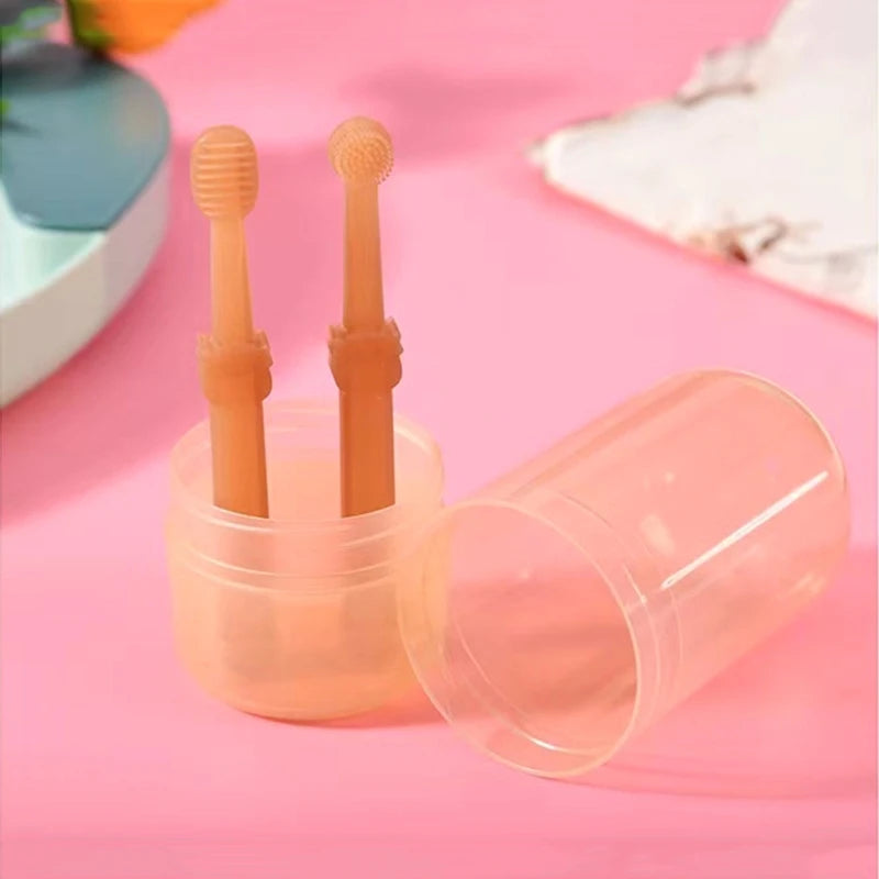 A silicone pet toothbrush set for cats and dogs with storage case, showing two orange toothbrushes inside a clear container.