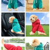 Un perro golden doodle vistiendo una sudadera verde de forro polar al aire libre.