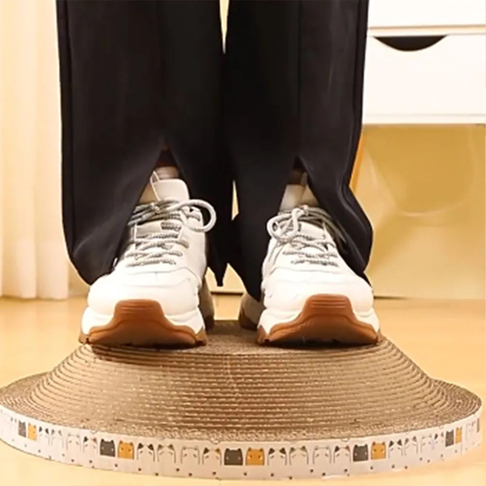 A pair of legs wearing black pants and white sneakers stand on a round, woven mat.