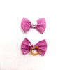 Pinker Glitzer-Schleifenknoten mit Perlenmitte und pinker Glitzer-Schleife mit Goldring