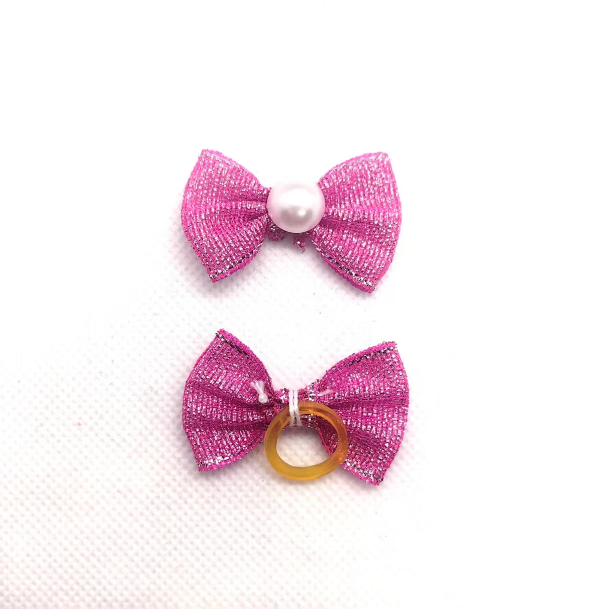 Pinker Glitzer-Schleifenknoten mit Perlenmitte und pinker Glitzer-Schleife mit Goldring