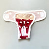 A reusable dog diaper pant in red and white with a bow detail, shown flat.