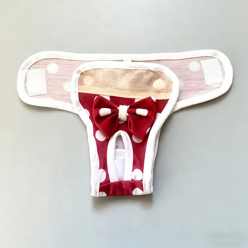A reusable dog diaper pant in red and white with a bow detail, shown flat.