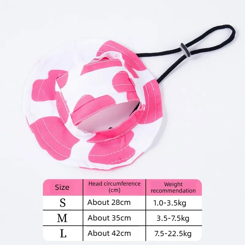 White bucket hat with pink cartoon print and black tie, available in sizes S, M, and L.
