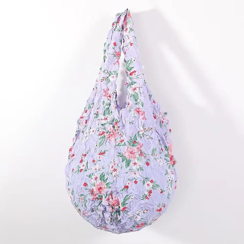 A reusable foldable bubble shopping bag in light purple with a floral print.
