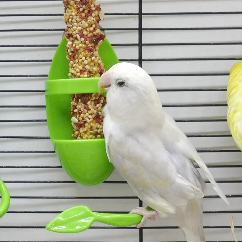 A white parrot is feeding from a green shuttlecock style cuttlebone on a wire grid.