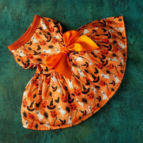 Vestido de cosplay para perro naranja con estampado de murciélagos y calabazas y un lazo naranja.