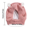 A pink knit beanie with bunny ears, designed as cozy ear muffs for dogs.