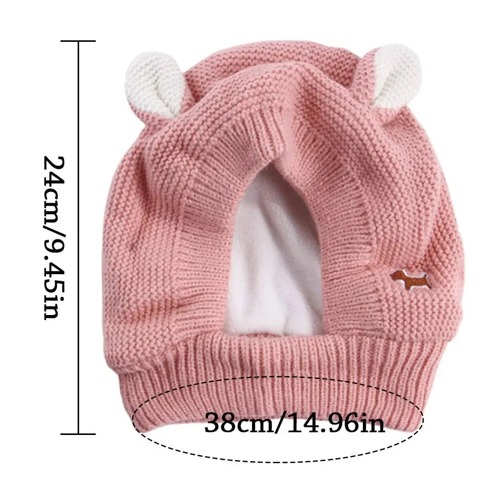 A pink knit beanie with bunny ears, designed as cozy ear muffs for dogs.