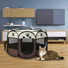 A portable foldable pet playpen with a black and gray fabric design resting on a wooden floor.