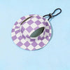 A purple and white checkered bucket hat with a black strap is shown against a light blue background.