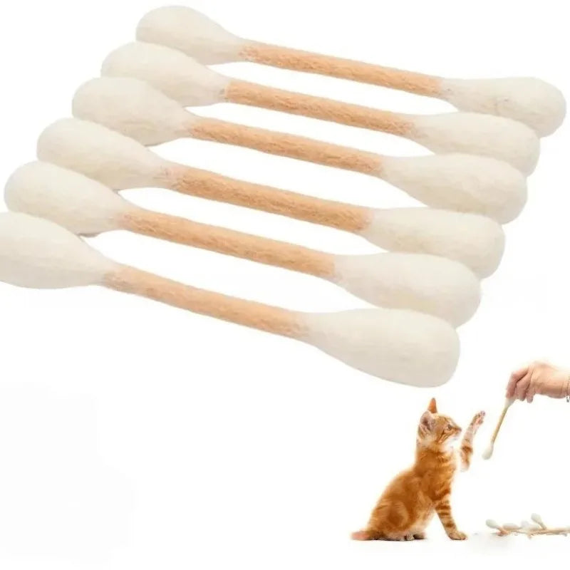 A set of giant cotton swab shaped catnip toys arranged in a fan pattern next to a small orange kitten.