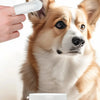 A dog looks at a hand holding pet ear wipes, with a container of pet ear cleaner finger wipes in the foreground.