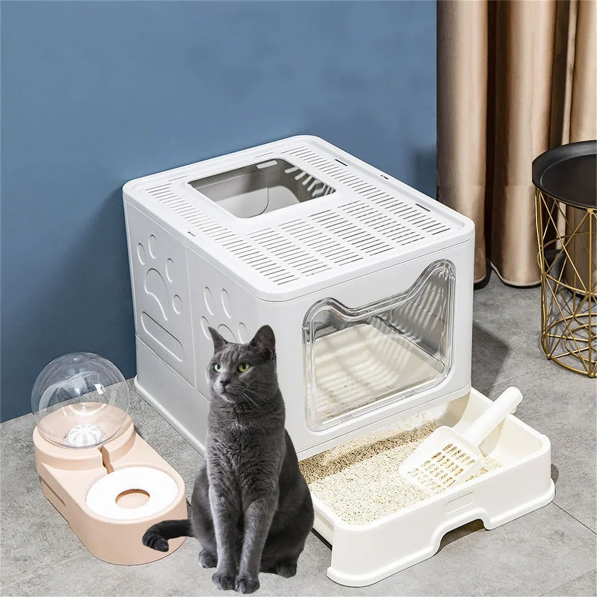 A white foldable cat litter box with a front entry and top exit is shown on a gray floor.