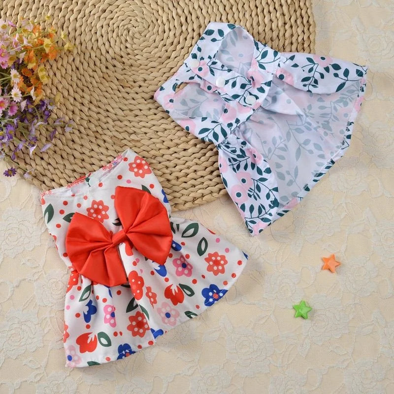 Robe d'été florale rose pâle et blanc avec un nœud orange, à côté d'un tissu blanc et rose transparent froncé.