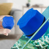 Une main tient un petit outil de nettoyage bleu pour nettoyer le verre d'aquarium.