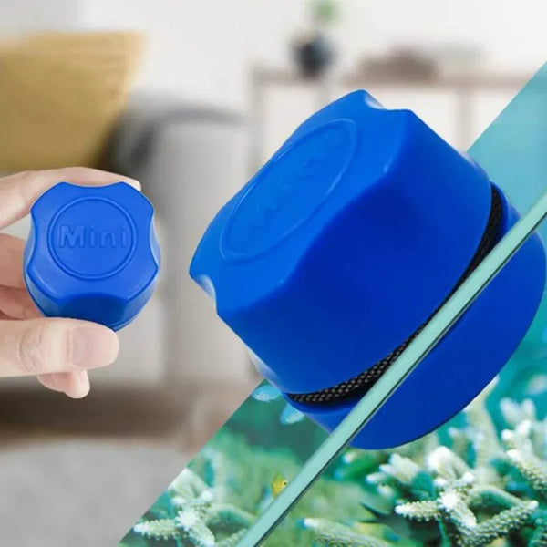 Une main tient un petit outil de nettoyage bleu pour nettoyer le verre d'aquarium.