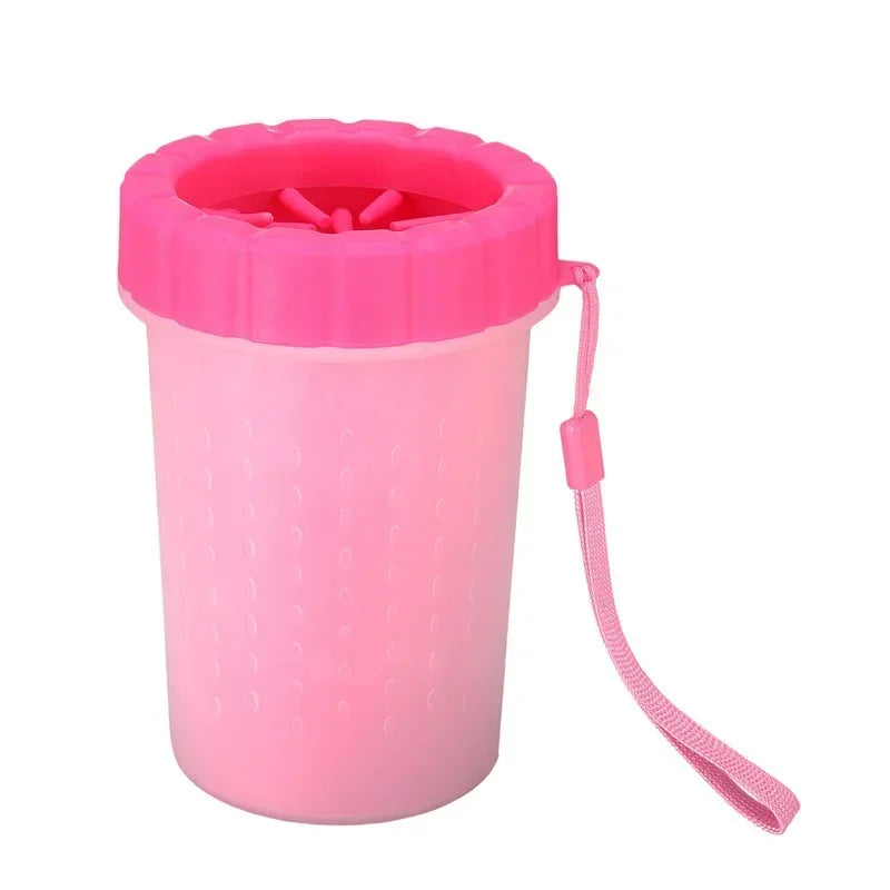 A pink silicone pet paw cleaner for dogs and cats with a handle.