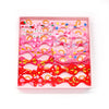 A pink tray filled with various adorable pet hair bows in shades of pink, red, and orange.