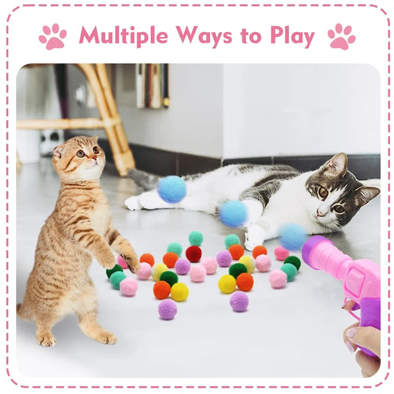 Eine tabbykatz spielt mit farbenfrohen Plüschbällen und einer rosa Spielzeugpistole.
