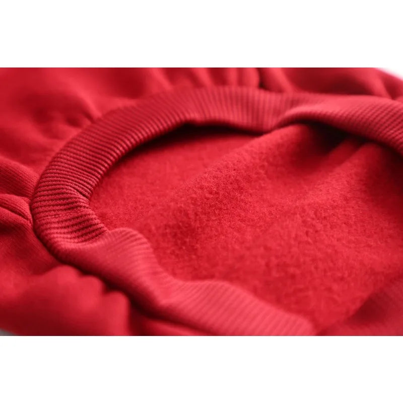 Close-up of a red fleece dog sweatshirt with ribbed cuffs and a rounded neckline.