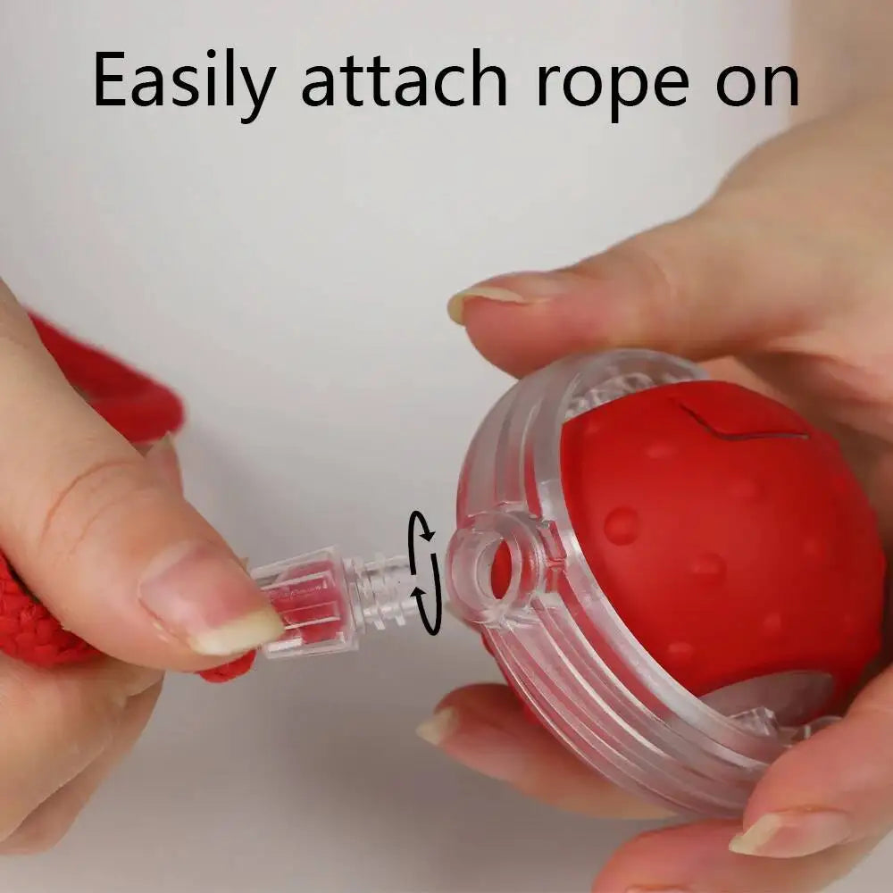Hands easily attach a rope to a red motion-activated cat toy ball.