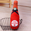 An orange bottle-shaped squeaky plush dog toy with a green paw print design sitting in a wire basket.