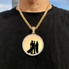 A gold chain necklace features a circular pendant with a black silhouette of two people.