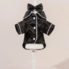 Pijamas para perro de satén negro con cinta para la cabeza, exhibidos en un maniquí blanco.