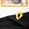 Yellow reusable pet grooming glove being worn on a hand against a black mesh fabric.