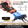 A hand holds an ultrasonic dog driver device with orange accents, demonstrating its use for dog training.