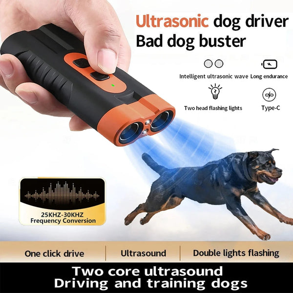 A hand holds an ultrasonic dog driver device with orange accents, demonstrating its use for dog training.