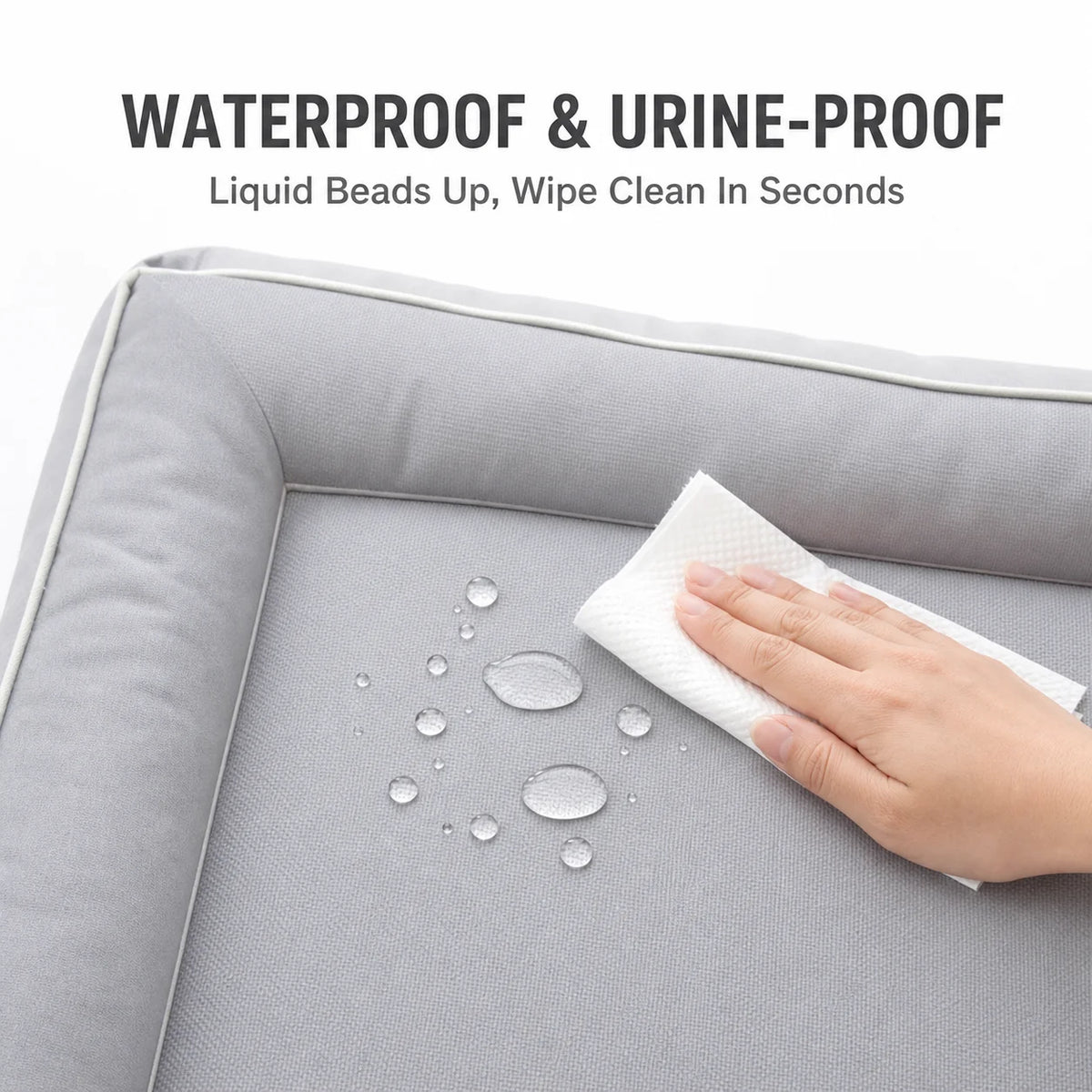A hand wipes liquid beads off a gray pet mat, demonstrating its waterproof and urine-proof features.