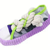 A purple and white slipper featuring a rope tie closure with light green accents.