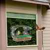 Nourrice pour oiseaux à fenêtre avec ventouses, montée sur l'extérieur d'une maison, avec un plateau rempli de graines.