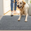 Un perro golden retriever está de pie en una alfombrilla para mascotas gris antideslizante y absorbente en interiores.