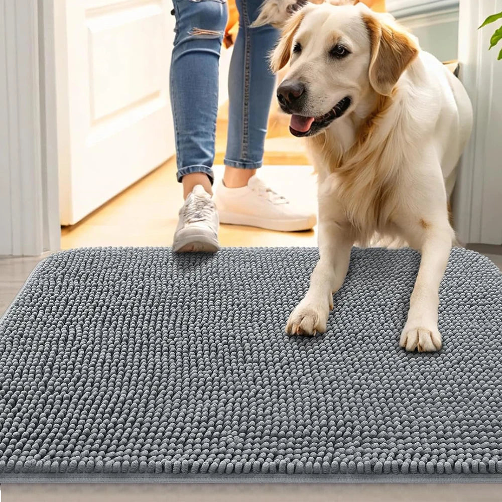 Un perro golden retriever está de pie en una alfombrilla para mascotas gris antideslizante y absorbente en interiores.