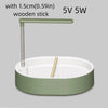 A light green automatic bird bathtub with a resting stick and a wooden stick inside.