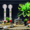 Vertikaler, schwebender Aquariumthermometer mit Glasröhre und Skala in einer Miniaturlandschaft.
