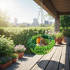 A small bird is resting in a green hanging hammock made of moss in an outdoor garden setting.