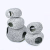 A stack of round, speckled ceramic aquarium decor pieces with drilled holes.