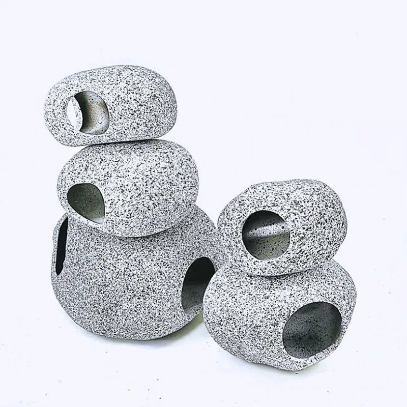 A stack of round, speckled ceramic aquarium decor pieces with drilled holes.