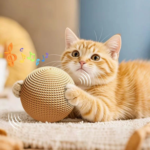 An orange kitten plays with a woven sisal scratching ball on a light-colored surface.