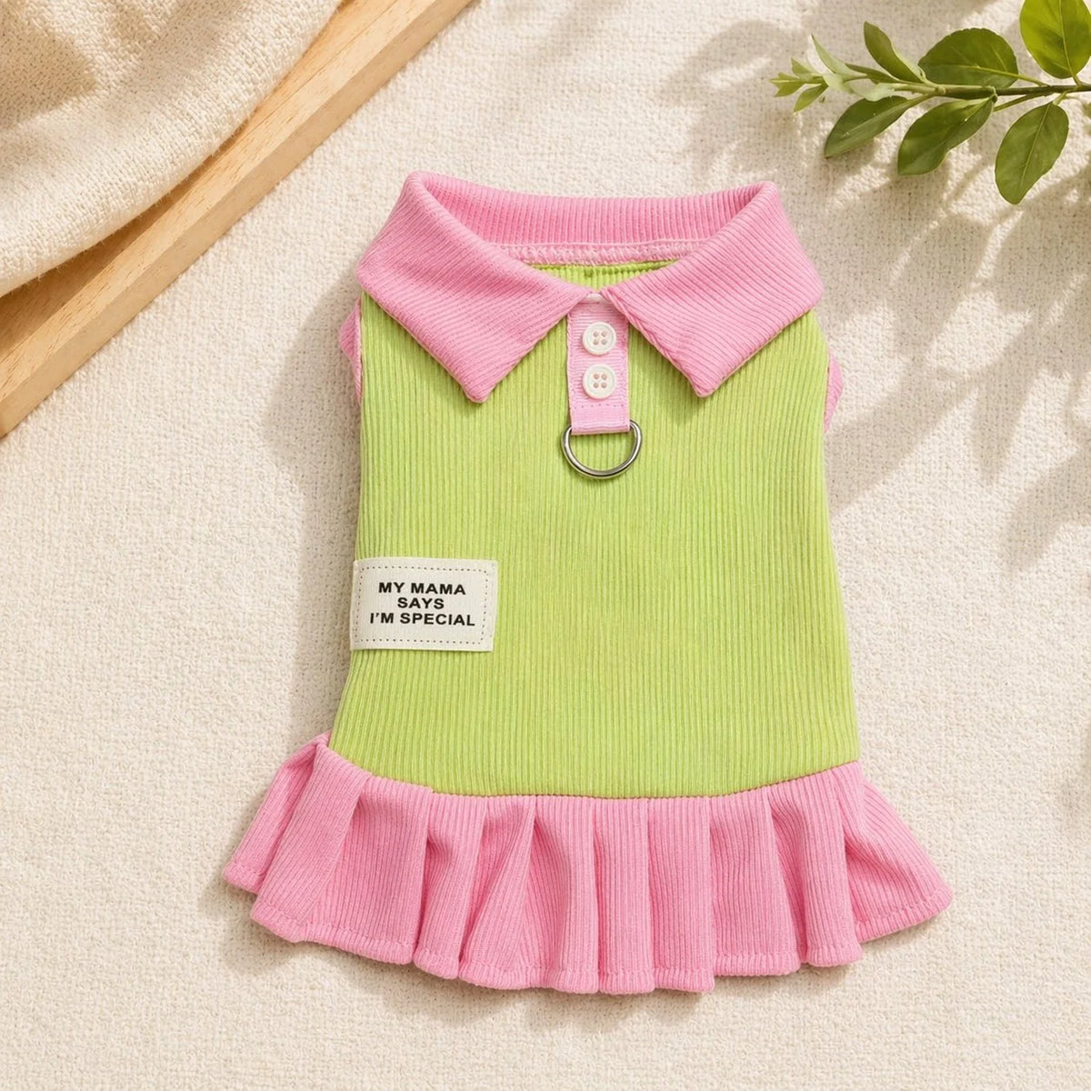 A pink and lime green short-sleeved dress for a child with a ruffled hem and a collar.