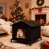 A black heated outdoor cat shelter with an arched entrance sits on a light rug in a living room setting.