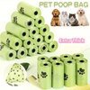 Une pile de sacs de déjections de chiens verts et plusieurs rouleaux individuels avec différentes races de chiens en arrière-