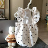 White pet dress for a small dog featuring polka dots and ruffled trim