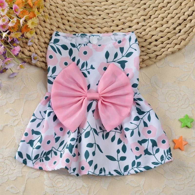 Robe d'été florale rose et blanche pour chien avec un grand nœud rose.