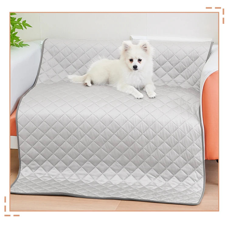 A fluffy white dog is lying on a gray quilted washable cooling mat.