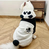 A white and black fleece dog coat with a panda design featuring black patches on the body and ears.